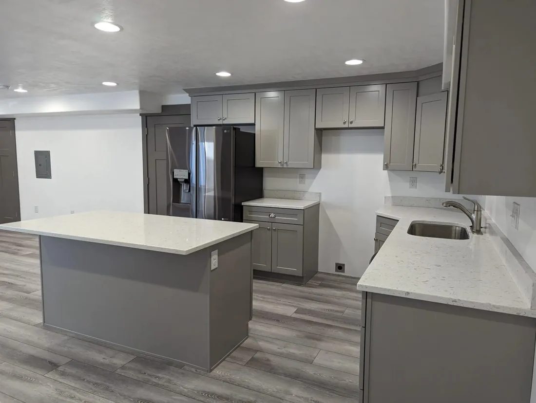 Kitchen remodel with grey island and white perimeter cabinets