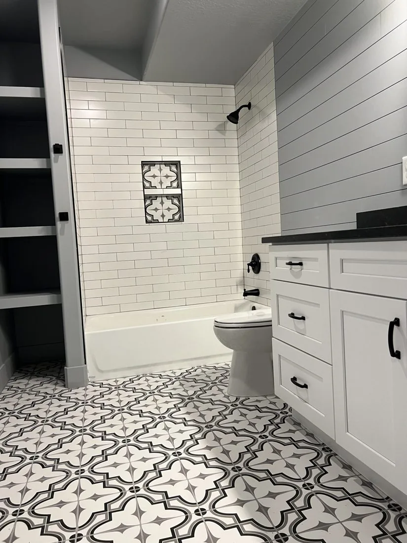 Bathroom with black and white patterned tile and custom tub surround