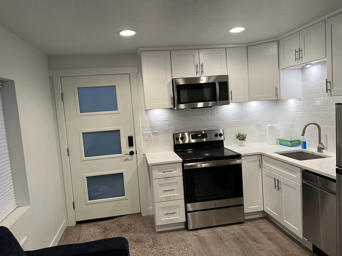 Remodeled white kitchen with stainless appliances and subway tile